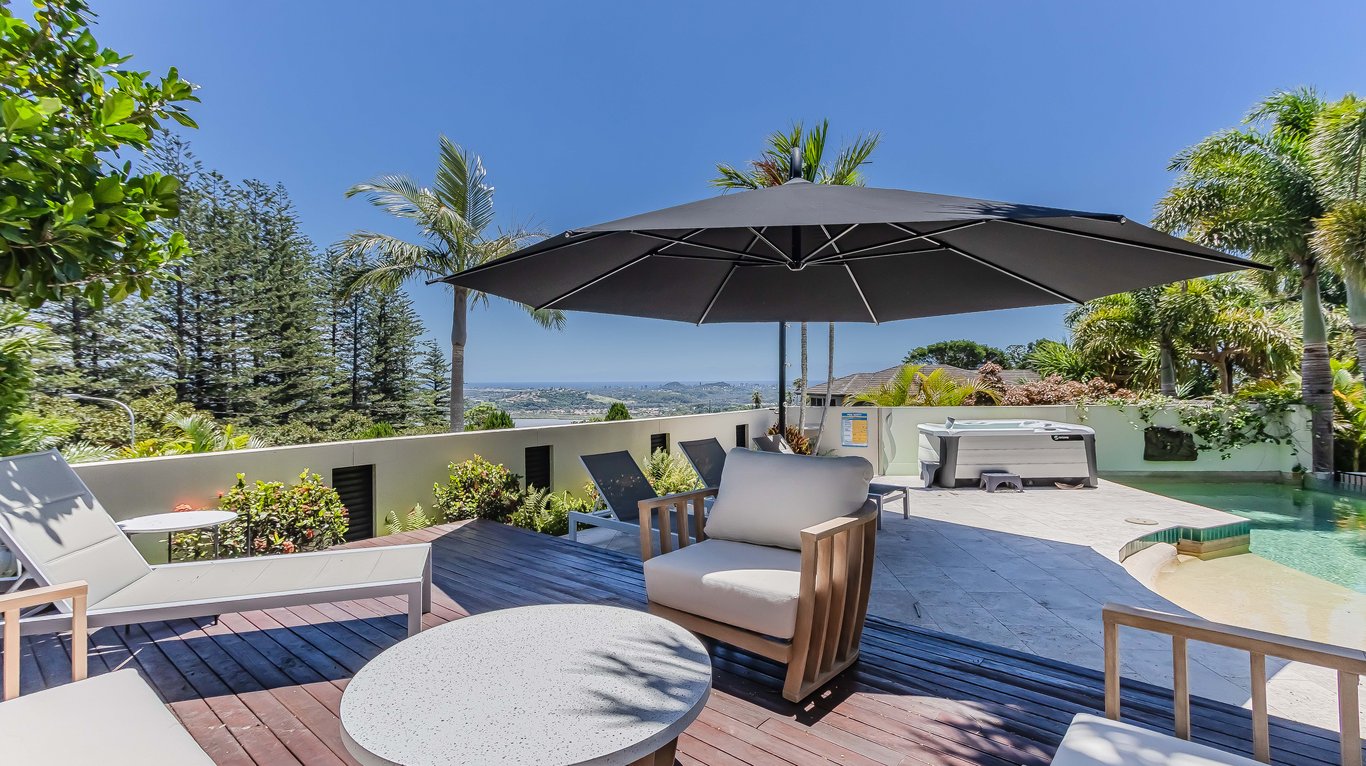 The pool deck, heated spa and coastal view